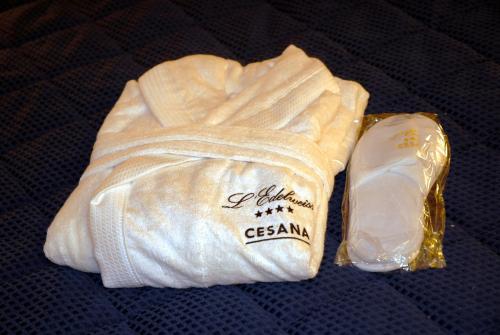 a white towel and a bar of soap on a bed at Hotel Edelweiss & SPA in Cesana Torinese