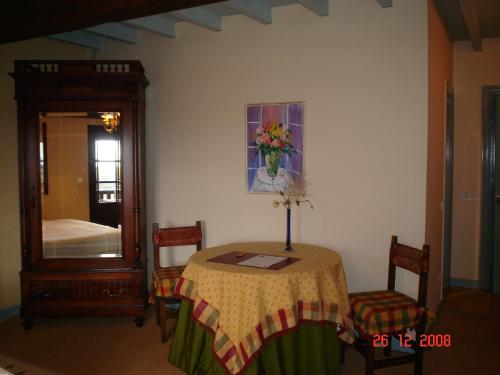 a room with a table with a vase of flowers on it at Casa de Güela in Santillana del Mar