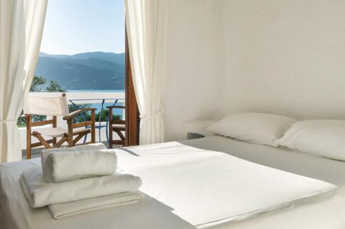 a bedroom with a white bed with a view of the ocean at Elounda Island Villas in Elounda