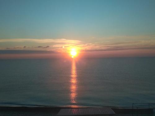 a sunset over the ocean with the sun reflecting in the water at Apartment Moe More in Odesa