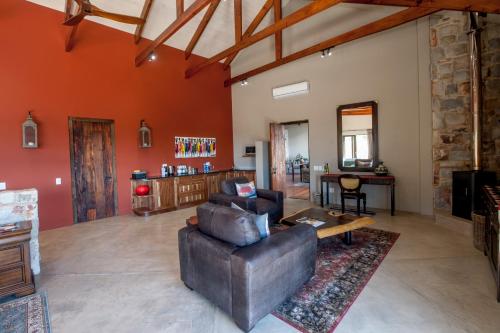 ein Wohnzimmer mit einem Sofa und einem Tisch in der Unterkunft Tamodi Lodge in Plettenberg Bay