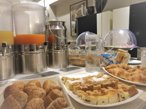 a counter with plates of pastries and other pastries at Hotel Guerrini in Venice
