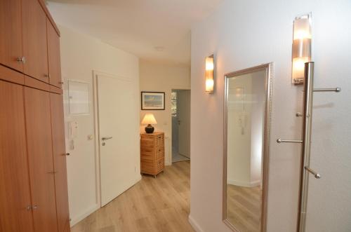 Cette chambre dispose d'un couloir avec un miroir et une porte. dans l'établissement Villa am Park - Apt. 02 Düne, à Sellin