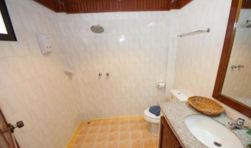 a bathroom with a shower and a toilet and a sink at Palmview Resort in Patong Beach