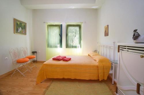 a bedroom with a bed with two red pillows on it at Ionian Queen Villa in Dhikhália