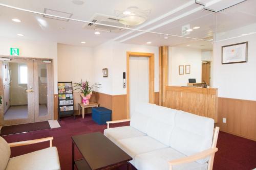 a waiting room with a white couch and a table at Hotel All In Stay Hakodate in Hakodate