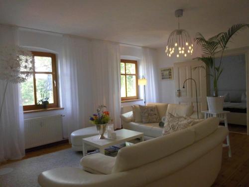 a living room with a couch and a table at SchlossparkFerienwohnungen Rheinsberg mit Garten in Rheinsberg