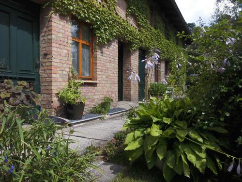 a brick house with plants on the side of it at SchlossparkFerienwohnungen Rheinsberg mit Garten in Rheinsberg