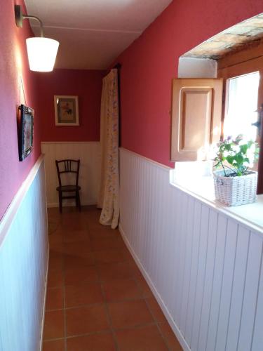 a hallway with red walls and a window at Casa Rural Luna in Candeleda