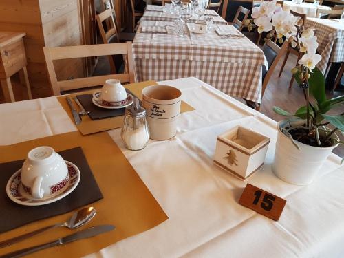a table with a white table cloth with a tea set at Hotel Pedretti in Branzi