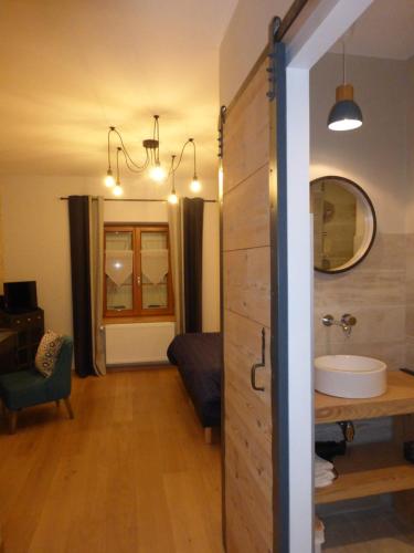 y baño con tocador, lavabo y espejo. en Chambres d'hôtes Béred Vuillemin, en Baume-les-Dames
