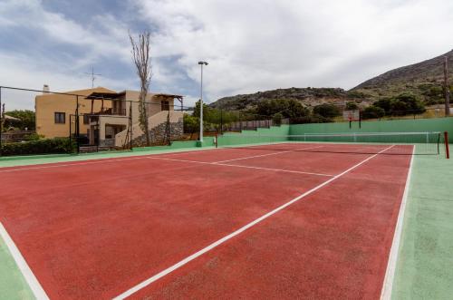 una pista de tenis frente a una casa en Ida villa en Hersonissos