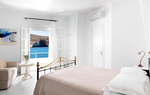 a white bedroom with a bed and a window at Melian Boutique Hotel & Spa in Pollonia