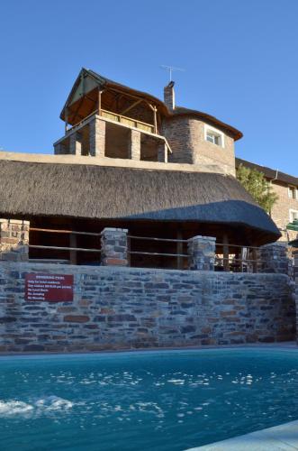 a building with a straw roof on top of the water at Seeheim Hotel in Seeheim