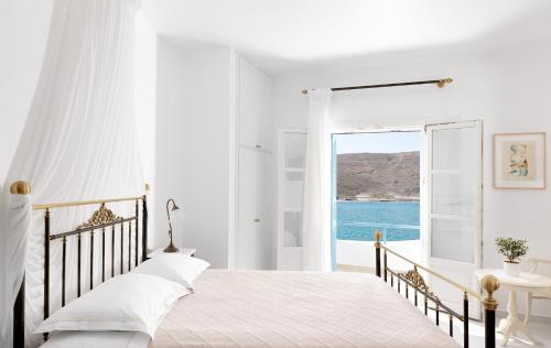 a bedroom with a bed with a view of the ocean at Melian Boutique Hotel & Spa in Pollonia