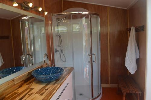 a bathroom with two sinks and a shower in it at First Light Rangihaeata Retreat in Takaka