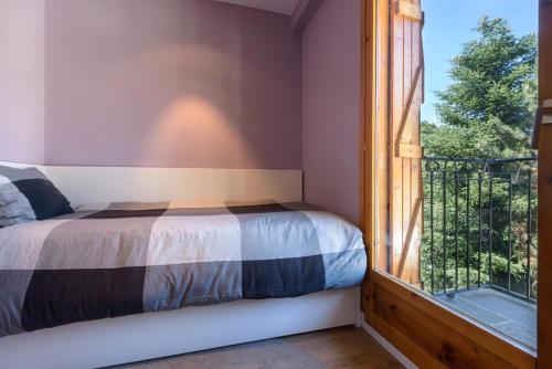 a bedroom with a bed next to a window at Panticosa Brazato in Panticosa