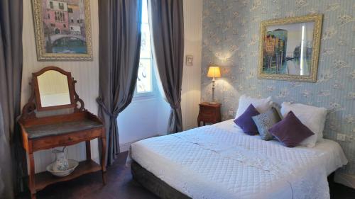 a bedroom with a bed and a mirror and a chair at Hotel Relais Du Postillon in Antibes