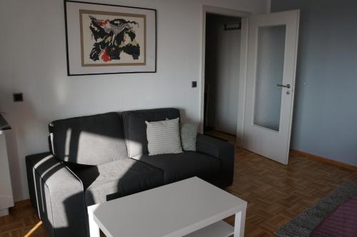 a living room with a black couch and a table at Köln Deutz/Messe, Lanxess Arena in Cologne