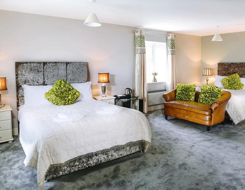 a bedroom with a large bed and a chair at Coast Lodge in Spanish Point