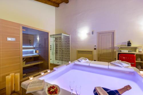 a large bath tub in a room with a kitchen at Hotel Sa Cheya Relais & Spa in Alghero