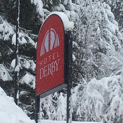 a sign for a hotel depot in the snow at Hotel Derby in Folgarida