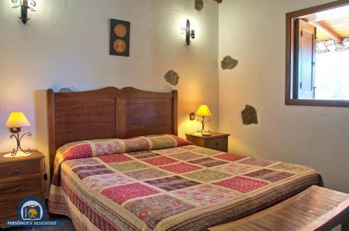 テヘーダにあるCasa rural El Coronelのベッドルーム1室(大型ベッド1台、ナイトスタンド2台付)