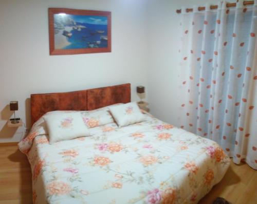 a bedroom with a bed with a floral bedspread at Birds House - Village Marina in Olhão