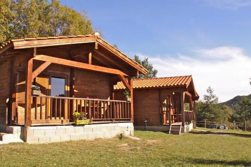 a log cabin with a porch and a balcony at Camping Ripolles in Ripoll