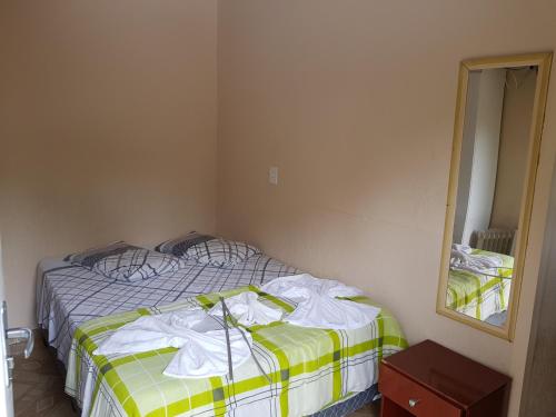a bedroom with a bed with towels on it at Pousada Miniférico in Campos do Jordão