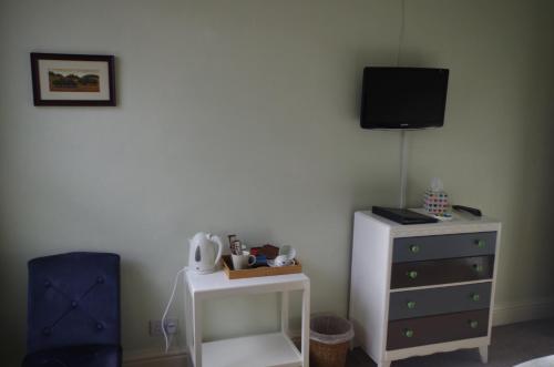 a bedroom with a dresser and a tv on the wall at Varley House in Ilfracombe