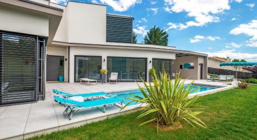 a villa with a swimming pool and a house at Maison Cube in Saint-Didier-au-Mont-dʼOr