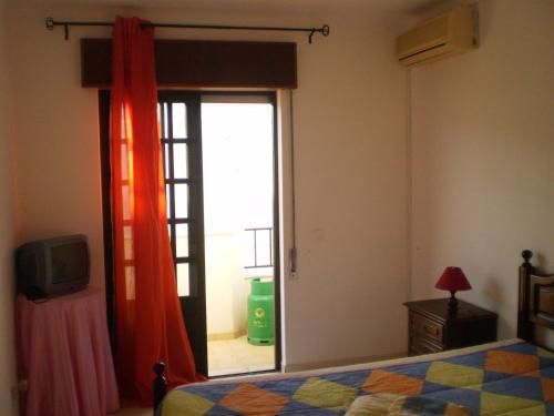 een slaapkamer met een bed en een glazen schuifdeur bij Lagar in Manta Rota