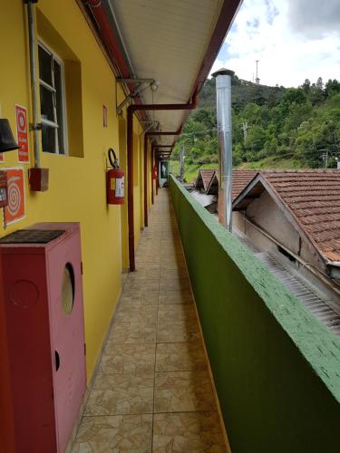 a hallway of a building with a green and yellow wall at Pousada Miniférico in Campos do Jordão