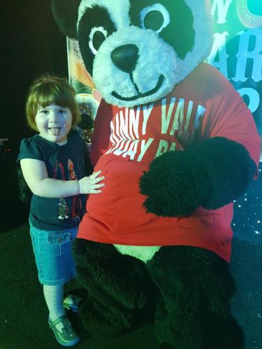 a young child standing next to a giant panda bear mascot at Sunnyvale Holiday Park in Saundersfoot