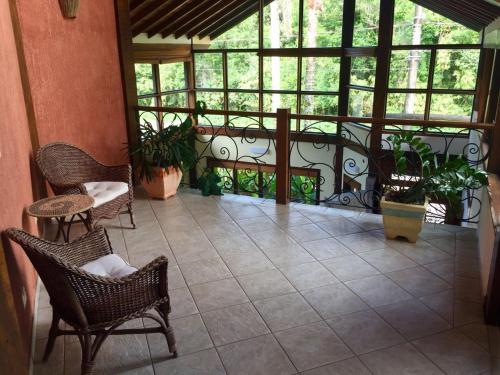 a screened in porch with chairs and plants at Pousada Samburá in Barra do Una