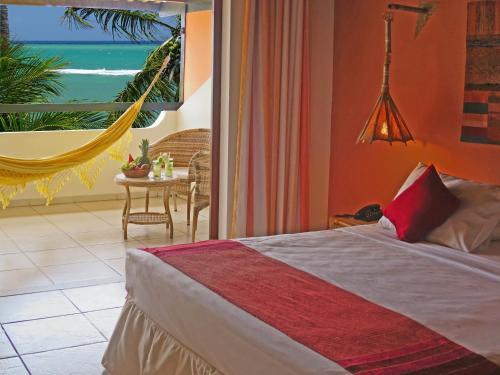 a bedroom with a hammock and a view of the ocean at Porto da Lua Boutique Hotel in Praia do Forte