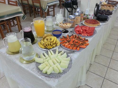 een tafel met borden eten en fruit erop bij Hotel Praia Grande in Penha
