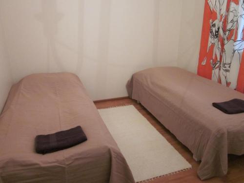 Habitación pequeña con 2 camas y alfombra. en Karijoen Helmi, en Karijoki