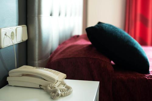 a telephone sitting on a table next to a bed at Hotel Cim Valles in Santa Perpetua de Moguda