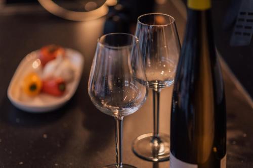 two wine glasses sitting next to a bottle of wine at Goitzsche Resort in Bitterfeld