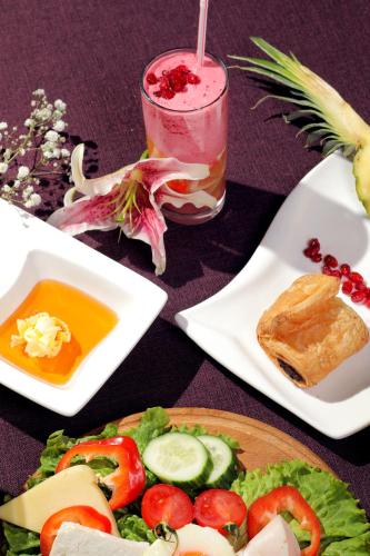 a table with a plate of food and a drink at Mercure Tetovo in Tetovo