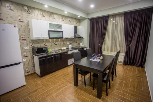 een keuken met een zwarte tafel en een witte koelkast bij Spacious 2 bedroom apartment in Tbilisi City