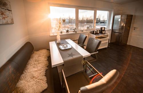 a living room with a table and chairs and a refrigerator at Goitzsche Resort in Bitterfeld