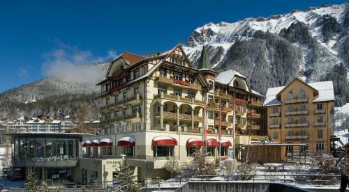 ヴェンゲンにあるHotel Victoria Lauberhorn Wengen, a Faern Collection Hotelの山の前にある大きな建物