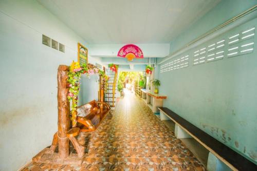 a hallway of a building with a bench and flowers at Sabaydee House at Pai in Pai