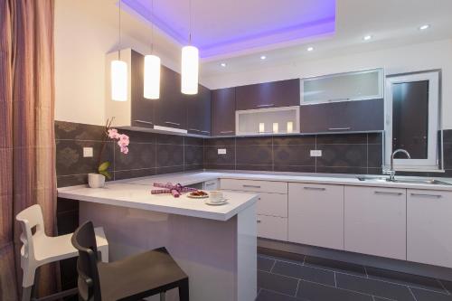 a kitchen with white cabinets and a sink at Apartmani Pašalić in Tučepi