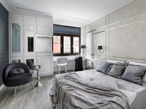 a bedroom with a large bed and a chair at Sweet Suite in Gdańsk