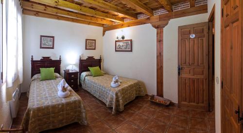 a bedroom with two beds with green pillows at Majada De Sigueruelo in Sigueruelo