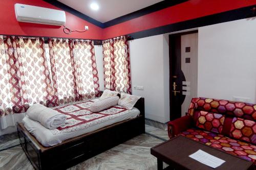 a bedroom with a bed and a couch at Asian Grand Villa in Bolpur